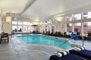 uma piscina num hotel com cadeiras e uma mesa em Homewood Suites by Hilton Burlington em Burlington