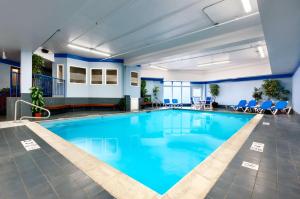 a pool in the lobby of a hotel with blue chairs at Hampton Inn Burlington - Colchester in Burlington