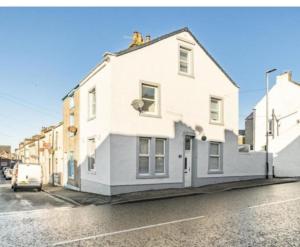 una casa blanca al costado de una calle en Ennerdale Edge - 4 Bedrooms - Sleeps 8, en Cleator Moor