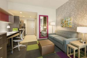 a living room with a couch and a kitchen at Home2 Suites By Hilton Williamsville Buffalo Airport in Williamsville