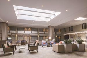 a lobby with chairs and tables and a skylight at Doubletree by Hilton Laurel, MD in Laurel