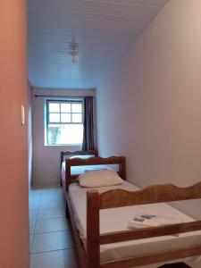 a room with three beds and a window at Hospedaria Mineira Hostel Pousada in Ouro Preto
