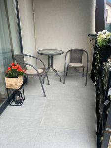 two chairs and a table and two tables and chairs at Apartament 3 camere in Baia Mare
