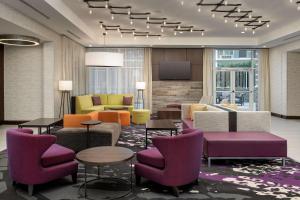 a hotel lobby with colorful chairs and tables at Hilton Garden Inn Columbia Airport, SC in Columbia
