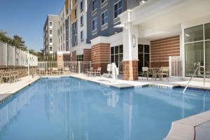 a large blue swimming pool in front of a building at Hilton Garden Inn Columbia Airport, SC in Columbia