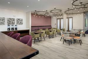 a dining room with tables and chairs and lights at Hilton Garden Inn Columbia Airport, SC in Columbia