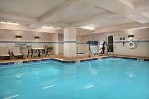una piscina en una habitación de hotel con mesa y sillas en Hampton Inn & Suites Canton, en North Canton