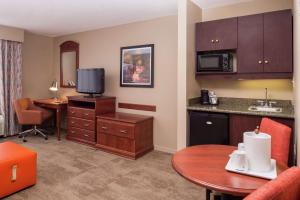 a hotel room with a kitchen and a desk with a table at Hampton Inn Columbia Northeast-Fort Jackson Area in Columbia
