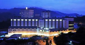 a large white building with lights in a city at night at Nova Highlands Hotel in Cameron Highlands