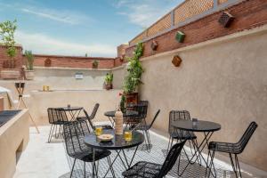 un patio con mesas y sillas en el balcón en Riad Celema & Spa, en Marrakech