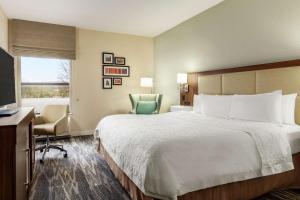 Habitación de hotel con cama, escritorio y TV. en Hampton Inn Akron-Fairlawn en Montrose