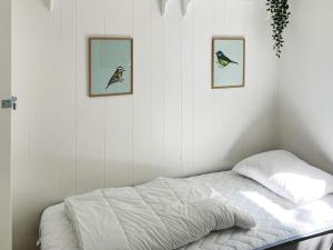 Bett in einem Zimmer mit drei Bildern an der Wand in der Unterkunft Holiday home Højby III in Højby