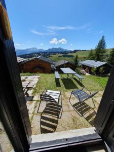 a group of picnic tables and benches in a yard at Les saisies-gîte les carolos in Les Saisies