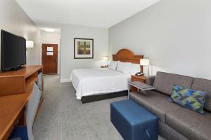 a hotel room with a bed and a couch at Hampton Inn Atlanta-Newnan in Newnan