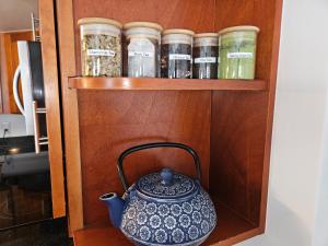 a tea pot sitting on a shelf with jars at Ilikai Hotel Condo with Kitchen and Ocean View in Honolulu
