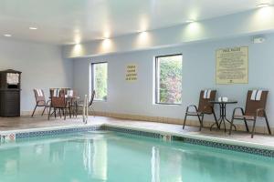 a swimming pool with chairs and tables in a room at Hampton Inn Akron-South in Akron