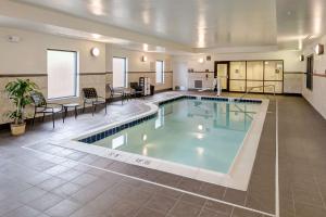a large swimming pool in a large room with tables and chairs at Hampton Inn Poplar Bluff in Poplar Bluff