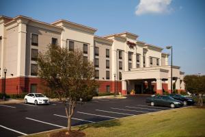 un estacionamiento con coches estacionados frente a un hotel en Hampton Inn Carrollton, en Carrollton