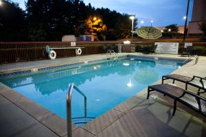 a swimming pool at night with two chairs next to it at Hampton Inn Carrollton in Carrollton