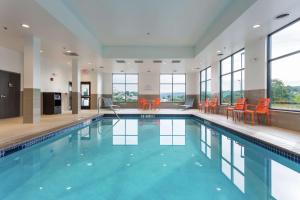 a swimming pool with orange chairs in a building at Hampton Inn Cumberland in Cumberland