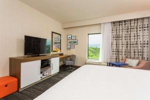 坎伯兰Hampton Inn Cumberland的一间配有床和平板电视的酒店房间