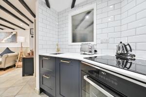 uma cozinha com um lavatório e um fogão forno superior em Luxury Couple's Getaway with River Views and Parking em Polperro