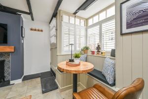 a room with a table and a chair and windows at Luxury Couple's Getaway with River Views and Parking in Polperro +14 photos