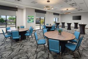 Hampton Inn Blue Ridge, GA في بلو ريدج: قاعة اجتماعات مع طاولتين وكراسي زرقاء