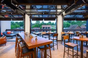 um restaurante com mesas e cadeiras e janelas grandes em Hampton Inn Blue Ridge, GA em Blue Ridge
