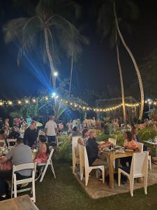 un grupo de personas sentadas en mesas en una fiesta en Casa Grande Hotel Restaurant, en Las Terrenas