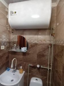 y baño con aseo blanco y lavamanos. en Dzīvoklis Tukuma centrā, en Tukums