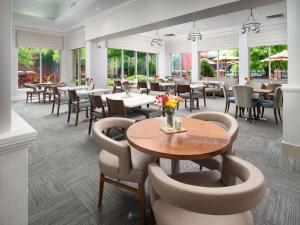 un restaurante con mesas, sillas y ventanas en Hilton Garden Inn Chattanooga Downtown, en Chattanooga