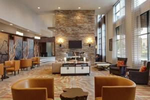 a lobby with couches and chairs and a tv at Embassy Suites Chattanooga Hamilton Place in Chattanooga