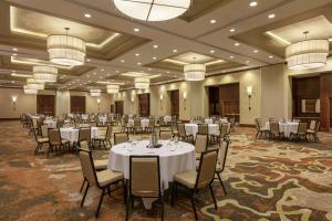 un salón de banquetes con mesas y sillas blancas y lámparas de araña en Embassy Suites Chattanooga Hamilton Place, en Chattanooga