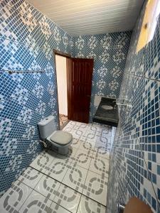 - une salle de bains pourvue de toilettes dans une chambre dotée de carrelage bleu dans l'établissement Pousada Sossego de Alter, à Alter do Chão