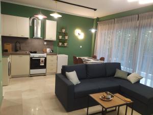 uma sala de estar com um sofá azul e uma cozinha em Sky Nomads em Tessalônica