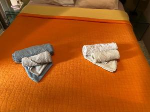 雅典的住宿－SoHoAthine Apartment，床上的两条毛巾和橙色床单