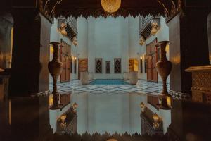 an empty room with a pool in the middle of a building at Riad Deluxe in Marrakech