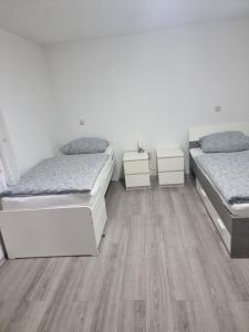 two beds in a room with wooden floors at Ferienwohnung Safi in Sachsenheim