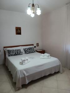 Un dormitorio con una cama blanca con dos platos. en Rita's House, en Bivona