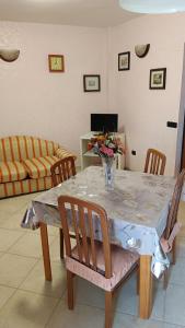 una mesa de comedor con un jarrón de flores. en Rita's House en Bivona