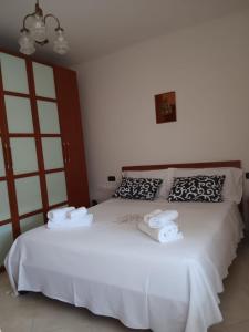 a bedroom with a white bed with two towels on it at Rita's House in Bivona