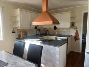 a kitchen with white cabinets and a stove top oven at Hus med utsikt over Alta elva in Alta