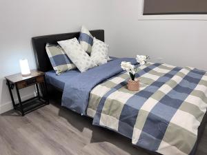 een bed met een blauwe en witte deken en een tafel met bloemen bij Private Entire Townhouse Retreat Close to Lake in Calgary