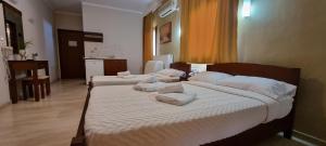 1 dormitorio con 2 camas y almohadas blancas en Manolas en Nei Poroi