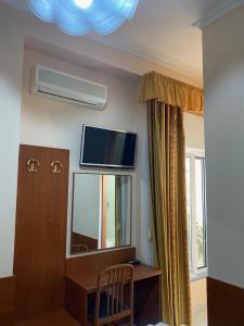 a room with a desk and a television on the wall at Guest House Pitagora in Rome