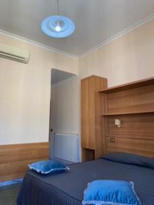 a bedroom with a bed with blue pillows on it at Guest House Pitagora in Rome