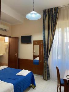 a bedroom with a blue bed and a flat screen tv at Guest House Pitagora in Rome