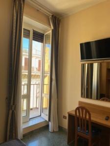 a room with a desk and a window with a television at Guest House Pitagora in Rome