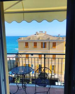 balcone con tavolo, sedie e vista sull'oceano di Il Sogno di Contardi A Affittacamere a Monterosso al Mare